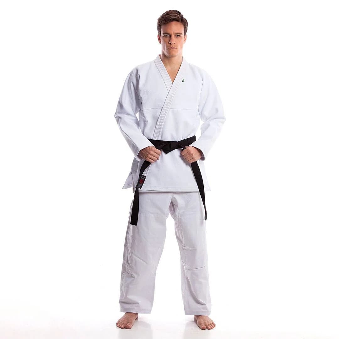 Martial arts team wearing custom logo jiu jitsu uniforms with embroidered patches and branding, standing proudly together.